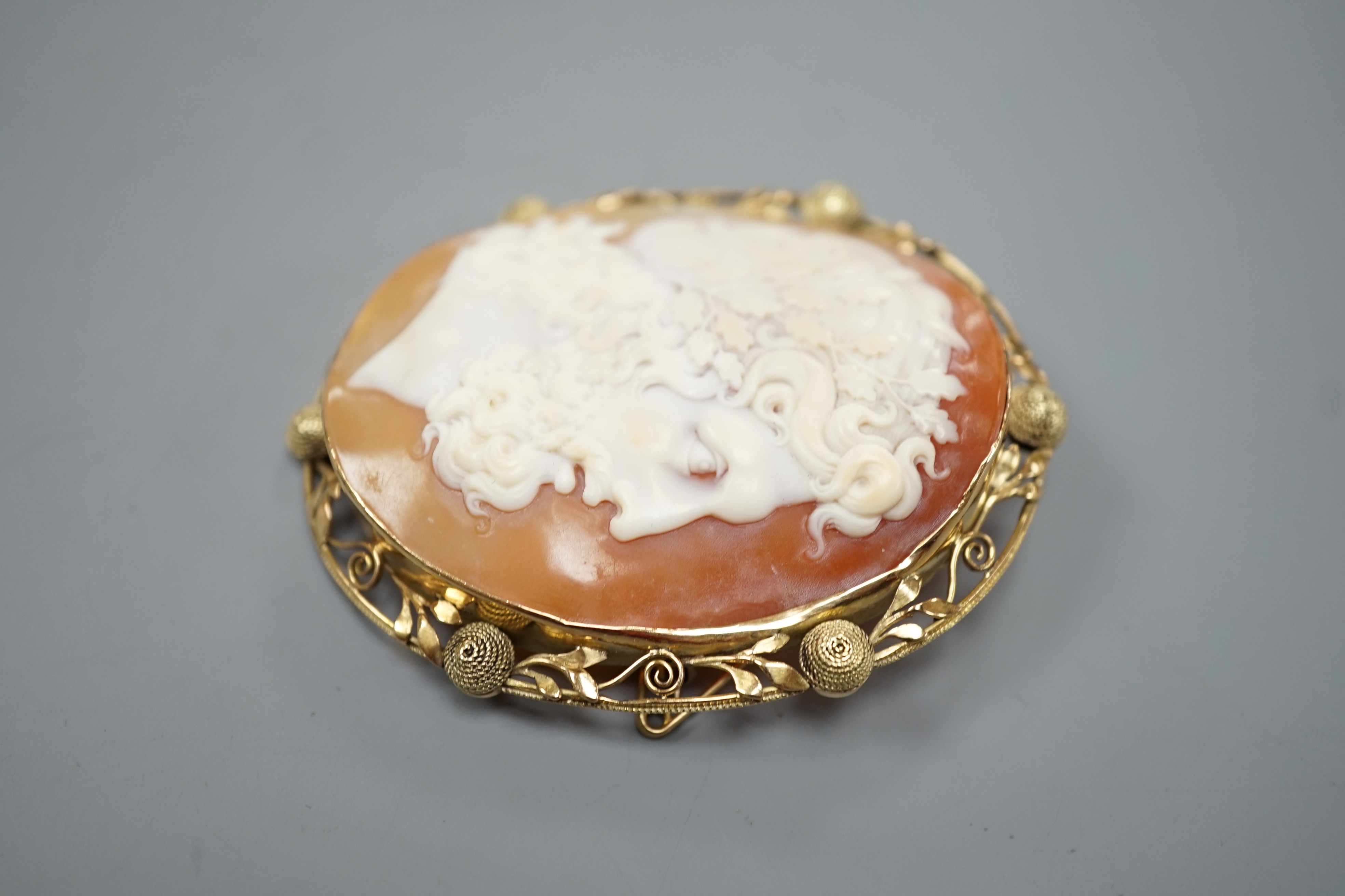After the antique- A yellow metal mounted oval cameo shell brooch, carved with the head of a Zeus to sinister, 62mm, gross weight 20.7 grams.